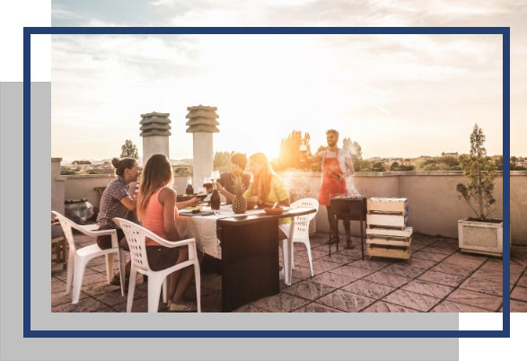 People on a rooftop in full sun enjoying a meal.